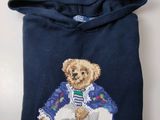 pull bleu orné d'un ours en peluche en tenue de marin et d'un seau rempli de jouets