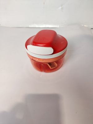 une petite boîte rouge avec un couvercle blanc posée sur une table