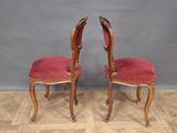 pair of red velvet upholstered chairs with carved wood legs