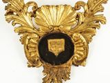 une broche dorée et noire ornée d'un bouclier