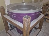 une grande casserole posée sur un support en bois dans une pièce