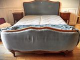 an image of a bed with a blue upholstered headboard