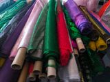 many different colors of fabric on display in a store
