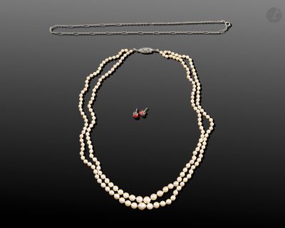 un gros plan sur un collier et une paire de boucles d'oreilles posés sur une table