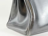 a close up of a silver purse on a white surface