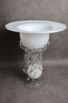 un vase en verre surmonté d'un bol blanc