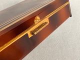 a brown box with a gold handle on a white surface
