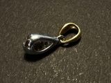 a close up of a silver and gold pendant on a table