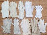 plusieurs paires de gants blancs posées sur une table en bois