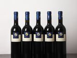 six bouteilles de vin sont alignées sur une table en bois