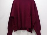 a maroon sweater hanging on a hanger against a white wall