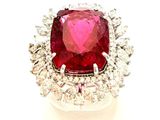 une photo d'une bague en diamant rouge et blanche posée sur une surface blanche