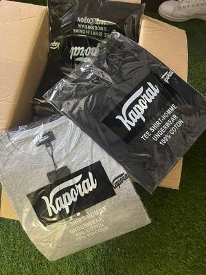 a box of t - shirts and a pair of shoes on the grass