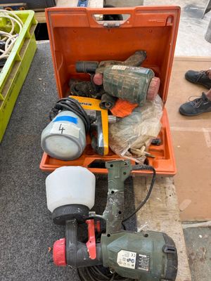 une boîte à outils posée par terre à côté d'une paire de chaussures