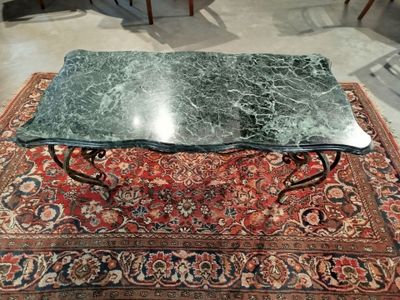 une table avec un plateau en marbre posée sur un tapis