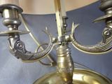 a brass plate with two candles on it and a lamp in the background