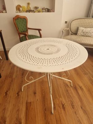 une table et des chaises blanches dans une pièce au sol en parquet