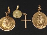 three gold medals and a cross on a black surface