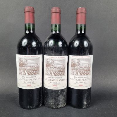 three bottles of red wine sitting on top of a table