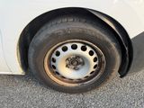 a close up of a tire on the side of a white car