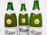 trois bouteilles de vin sont alignées sur une surface blanche