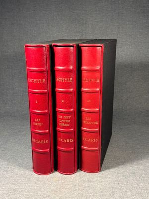 three red books sitting on top of each other on a table