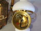 a wall mounted clock on a wall next to a wall light