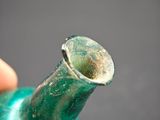 a person holding a green vase with a small hole in it