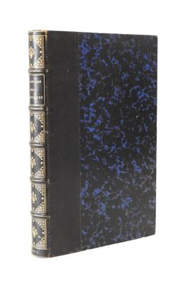 un vieux livre noir à la couverture bleue et aux bordures dorées