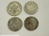quatre pièces de monnaie britanniques différentes posées sur une surface blanche