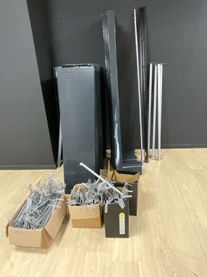 de nombreuses pièces métalliques posées sur une table, à côté d'une boîte de vis