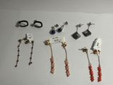 Plusieurs paires de boucles d'oreilles sont exposées sur une surface blanche