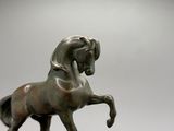 une statue en bronze représentant un cheval dressé sur ses pattes arrière