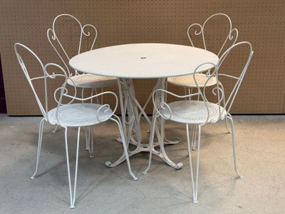 une table blanche entourée de quatre chaises dans une pièce