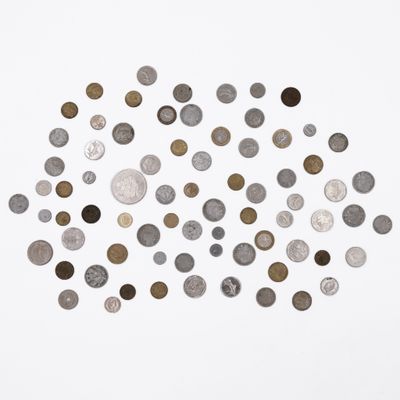 an overhead view of a pile of coins on a white surface