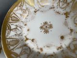 a gold and white plate with a flower design on it