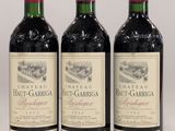 trois bouteilles de vin rouge posées sur une table blanche