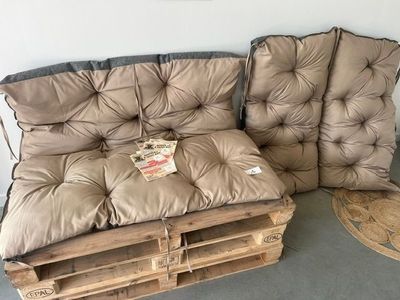 un canapé et un fauteuil fabriqués à partir de palettes dans une pièce