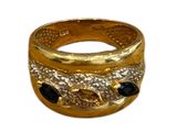 une image représentant une bague en or sertie de pierres noires sur fond blanc