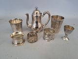 silver plated teapots, cups, and spoons on a table