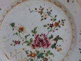 a plate with a floral design on it on a stand