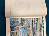 an open comic book on a table with a blue background
