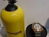 a watch sitting next to a yellow fire extinguisor