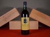 a bottle of wine sitting on a table next to two wooden boxes