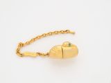 a gold bracelet with a green stone in the shape of a fish