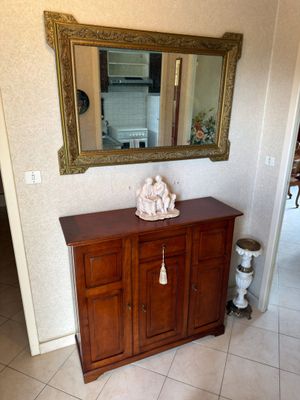 a wooden cabinet with a mirror on top of it