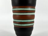un vase noir orné de rayures marron et bleues