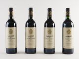 three bottles of wine are lined up on a white surface
