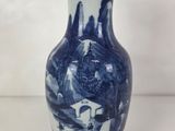 un vase bleu et blanc posé sur une table blanche