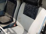 two seats in the back of a car with a steering wheel